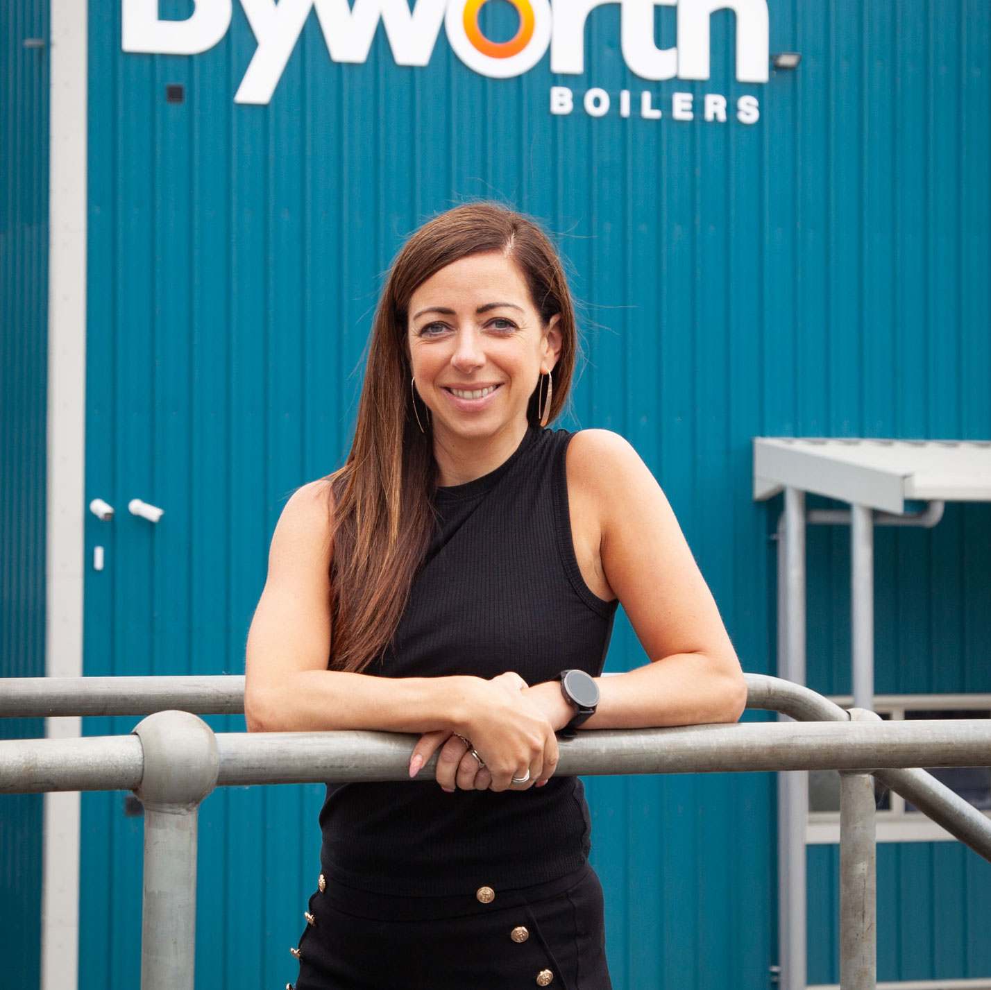 Smiling woman stood in front of a blue building